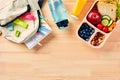 School lunch box with healthy food and school backpack with stationery on wooden background. Back to school concept. Top view. Royalty Free Stock Photo