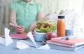 School lunch in a box and juice with fruit on a green background and books in the hands of a girl. Toast and juice in a bottle.