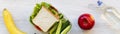 School lunch box with sandwich, fruits and bottle of water on a white wooden surface, top view. From above, overhead Royalty Free Stock Photo