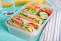 School lunch box with sandwich, vegetables, water, and fruits on table. Royalty Free Stock Photo