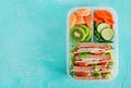 School lunch box with sandwich, vegetables, water, and fruits on table. Royalty Free Stock Photo