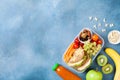 School lunch box with vegetables, fruits and sandwich for healthy snack on table top view. Royalty Free Stock Photo