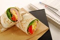 School lunch: ham and cheese wrap sandwich with lunch bag on the book Royalty Free Stock Photo