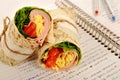 School lunch: ham and cheese wrap sandwich on notebook Royalty Free Stock Photo