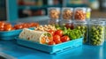 school lunch ideas, A vibrant selection of school lunch items, focused on a whole wheat wrap, cherry tomatoes, and assorted Royalty Free Stock Photo