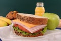 School lunch, sandwich and drink on classroom desk with blackboard Royalty Free Stock Photo