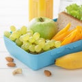 School lunchbox or bento with sandwich, fruits, vegetables, nuts and juice on white wooden background. Royalty Free Stock Photo