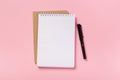 School notebook on a pink background, spiral notepad on a table