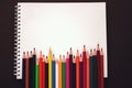 School notebook, Rainbow colored pencils are jiggling side by side. School accessories Royalty Free Stock Photo