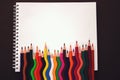 School notebook. Rainbow colored pencils are jiggling side by side. back to school concept, modern elementary education. flat lay Royalty Free Stock Photo