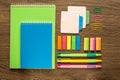 School and office stationery on wooden background. Notebook, notepad, pen, pencils and stuff. Top view flatlay