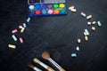 School and office supplies. Chalk scattered and paint brushes on the the old black board. Royalty Free Stock Photo