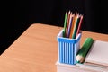 School and office supplies on classroom table in front of blackboard. View with copy space Royalty Free Stock Photo