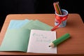 School and office supplies on classroom table in front of blackboard. View with copy space Royalty Free Stock Photo