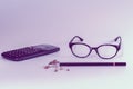 School or office supplies on a desk in feminine pink color with calculator, glasses, pencil and sharpener with wood shavings