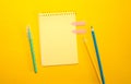 School or office supplies, note pad against yellow background. Flat lay, copy space Royalty Free Stock Photo