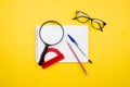 School and office supplies on yellow background. Back to school. Magnifier, protractor, sketchbook, pencil, eyeglasses Royalty Free Stock Photo