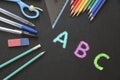 School and Office Utensils on a Chalkboard Surface with Colorful Letters Royalty Free Stock Photo