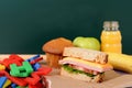 School packed lunch on classroom desk with blackboard, copy space Royalty Free Stock Photo