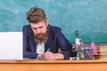 School paperwork. Paperwork part of teachers life. Teacher sit desk with laptop. Teacher bearded hipster with eyeglasses