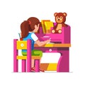 School girl studying sitting at pink child desk Royalty Free Stock Photo