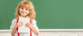 School pupil boy on blackboard, banner copy space. cheerful child boy in bow tie study in school classrrom showing