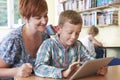 School Pupil With Teacher Using Digital Tablet In Classroom Royalty Free Stock Photo