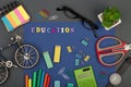 School set with blue paper, text `Education` of wooden letters, bicycle model, calculator, markers, scissors, eyeglasses, watch Royalty Free Stock Photo