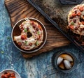 After school snack of a pizza bagel with a bite out of it served with a glass of cola.