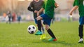 School soccer football game. Kids running after soccer ball on grass field