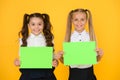 School socialization. Girls school uniform hold poster. Back to school concept. Schoolgirls show poster. Social poster