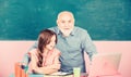 School Spirit. senior teacher help school girl. small girl with man tutor study on laptop. school shopping online Royalty Free Stock Photo