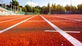 A school sports stadium featuring red artificial rubber ground running tracks with white lines, Ai Generated Royalty Free Stock Photo