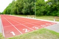 A school stadium running track with a red surface and six numbered lanes, athlete track Royalty Free Stock Photo