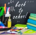 School stationery laid on a background of chalkboard