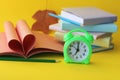 School stationery, open book, heart shaped pages, alarm clock on desk Royalty Free Stock Photo