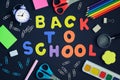 School and stationery are scattered on the black background. In the center of the inscription in colored letters, Back Royalty Free Stock Photo