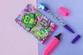 School stationery with stylish unicorn pen and owl scrap notebook on a pink and purple duotone background Royalty Free Stock Photo