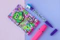 School stationery with stylish unicorn pen and owl scrap notebook on a pink and purple duotone background Royalty Free Stock Photo