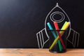 School stationery supplies and hand drawn rocket ship on dark background. Back to school concept. New idea and creativity Royalty Free Stock Photo