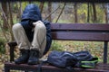 After school, a student upset in the park sits on a bench in an autumn park Royalty Free Stock Photo