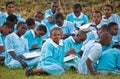 School students sit on the earth and wait for the school bus.