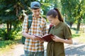 school students, a teenage boy and a girl are walking down the street, having fun, talking, reading books, a bright summer day in Royalty Free Stock Photo