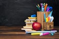 School supplies and accessories on wooden table over blackboard background Royalty Free Stock Photo