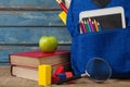 School supplies, apple, digital tablet and magnifying glass on wooden table Royalty Free Stock Photo