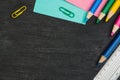 School supplies border on black chalkboard background. Top view photograph Royalty Free Stock Photo