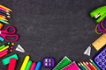 School supplies border frame, top view on a chalkboard background with copy space. Back to school.