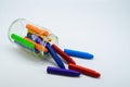 School supplies, colourful crayons stationery in clear jar on white background Royalty Free Stock Photo