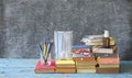 School supplies and COVID 19 prevention items on classroom desk with books,eyeglasses,pens on chalkboard background. Back to Royalty Free Stock Photo