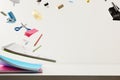 School supplies flying on desk white isolated background front